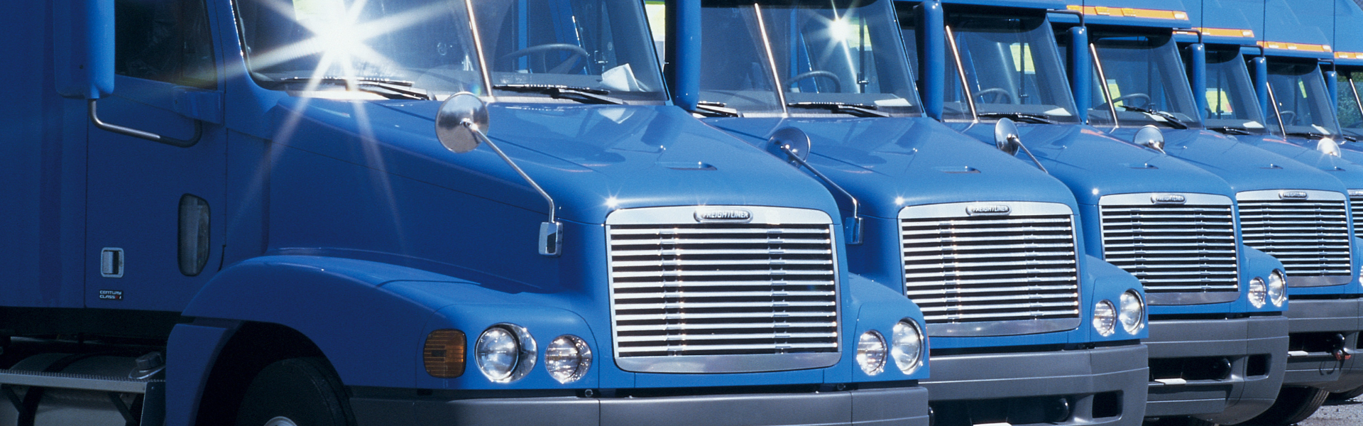 blue semi trucks parked in a row