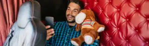 man in semi truck on facetiming while holding stuffed animal