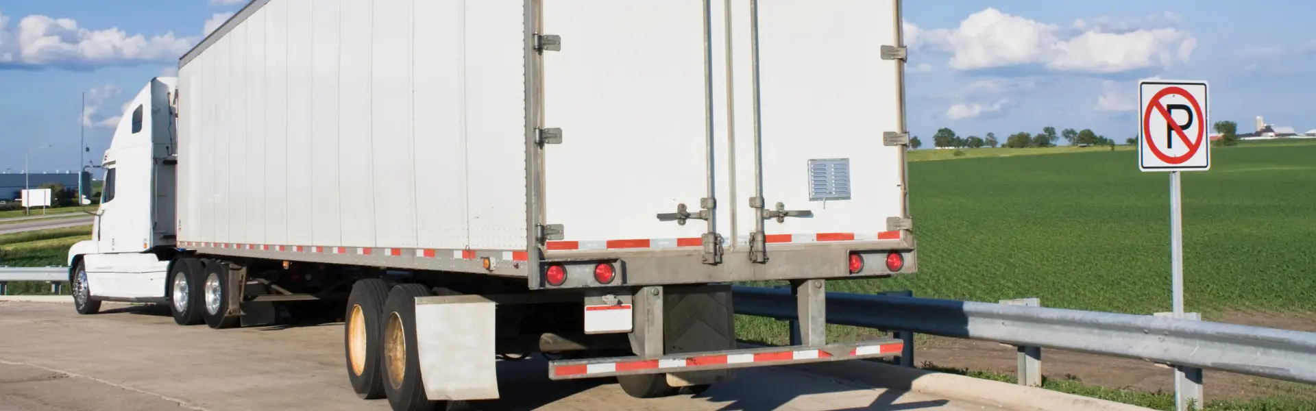 semi truck parked next to no parking sign