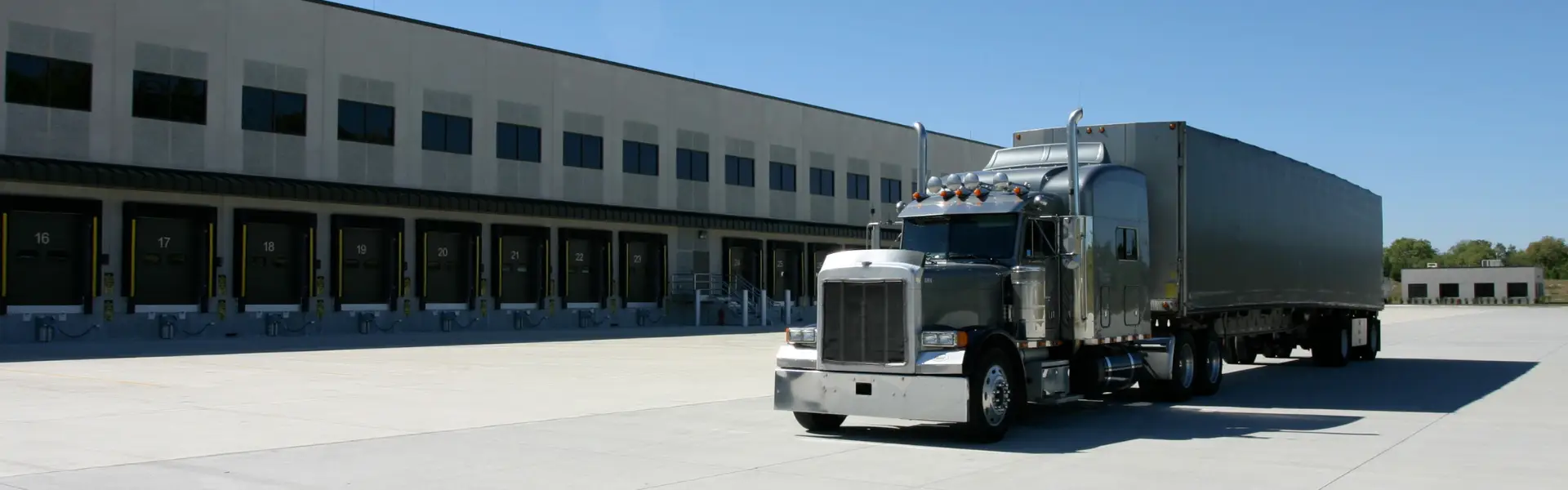 semi truck parked behind loading docks