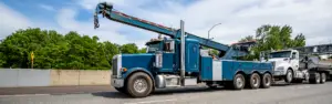 blue semi tow truck towing tanker semi truck