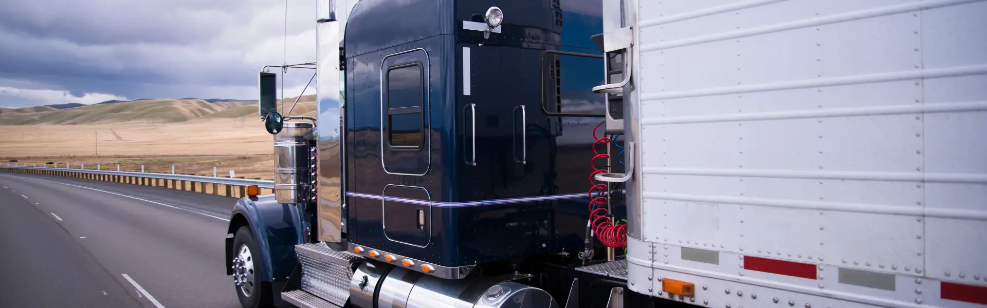 black semi truck pulling white semi on road