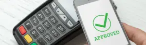 payment processed on mobile phone displaying green "approved" message with checkmark