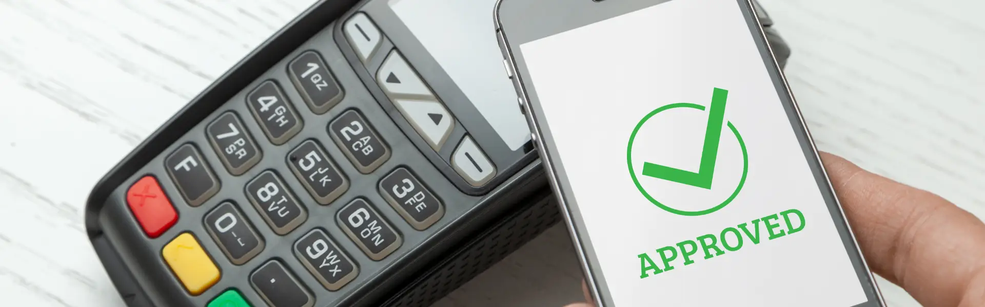 payment processed on mobile phone displaying green "approved" message with checkmark