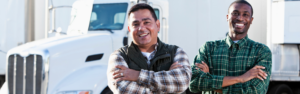 two men standing in front of semi truck