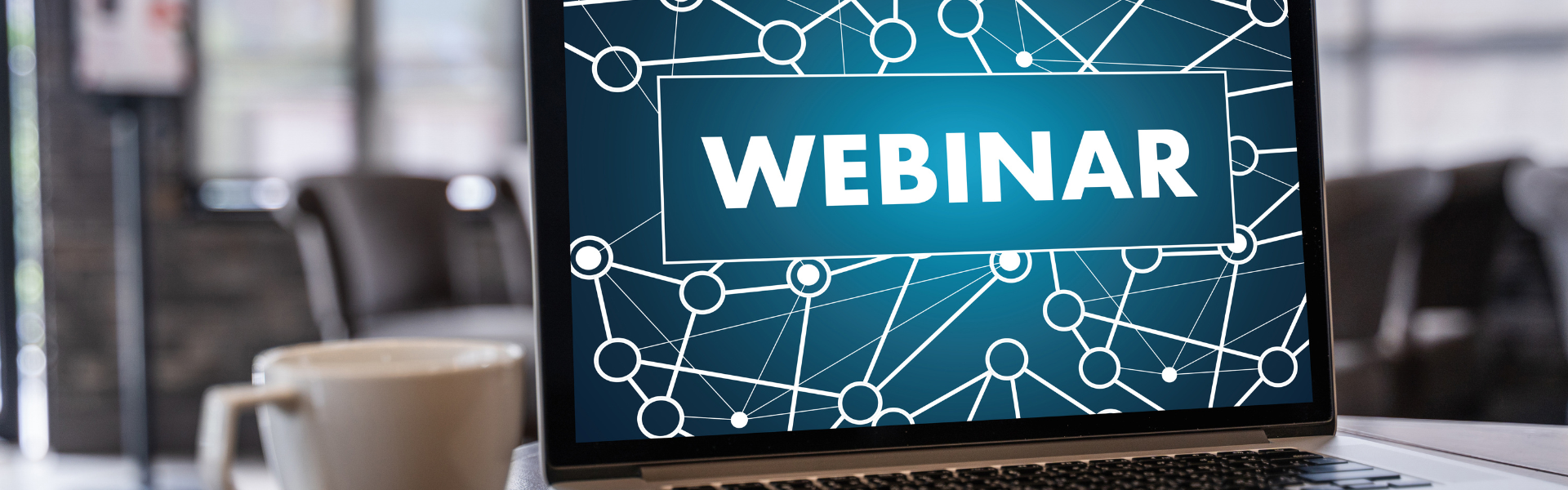 laptop open with webinar on screen and cup of coffee nearby