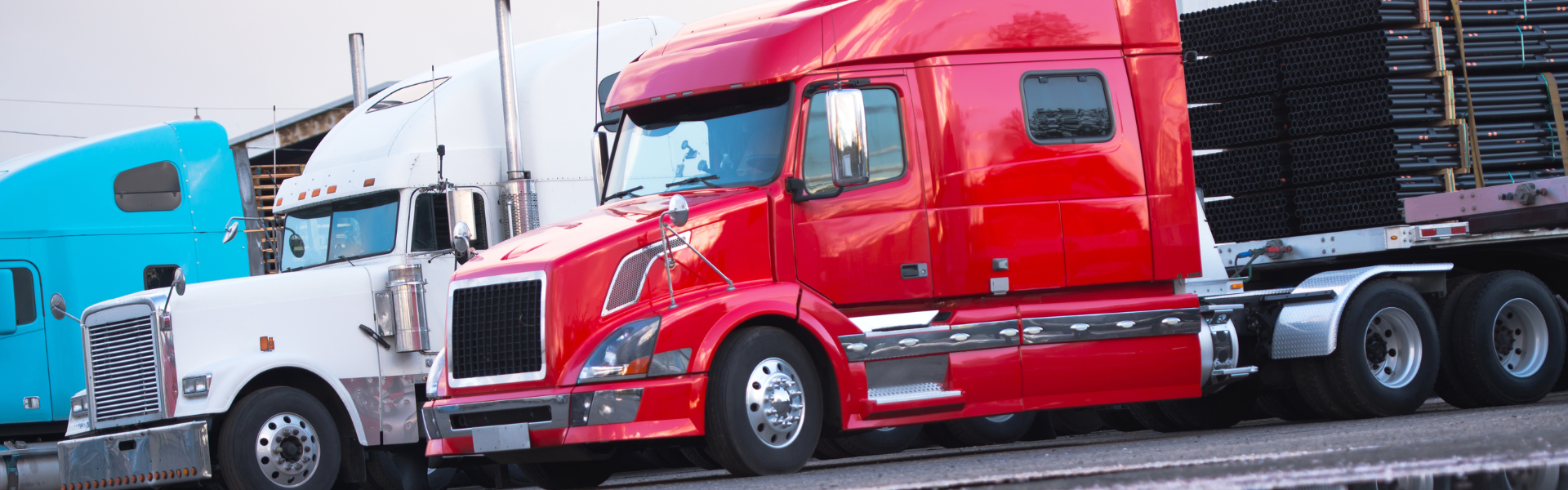 variety of semi trucks parked in a row
