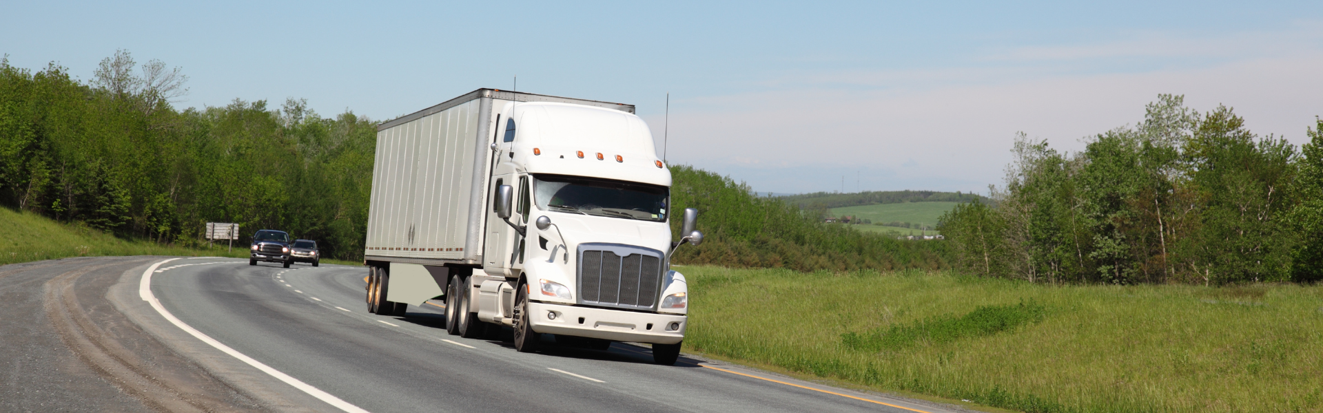 white semi truck with white trailer on road