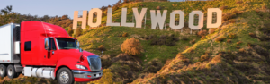 red semi truck in front of hollywood sign