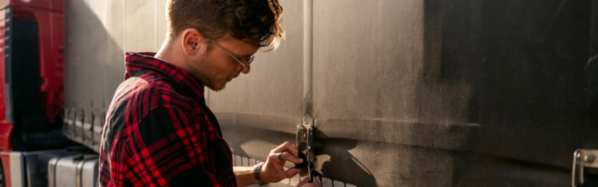 young man standing beside semi truck