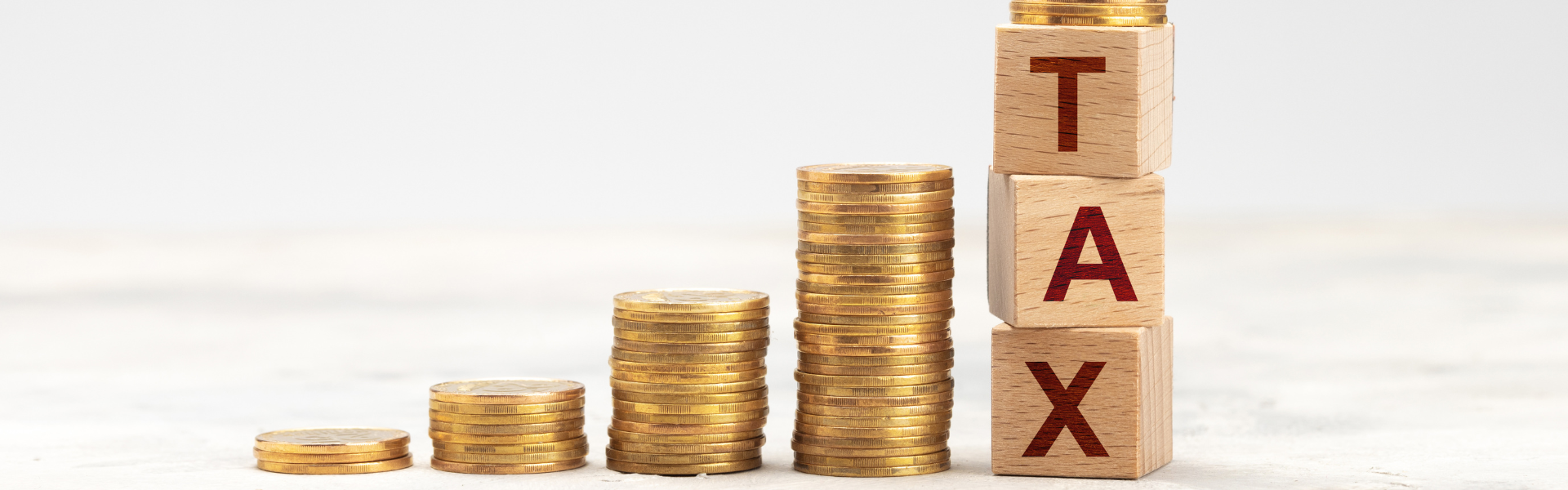 increasingly larger stacks of coins representing increasing taxes