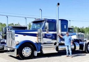 Long-time Peterbilt customer Mike Lowrie, president of Mike Lowrie Trucking in Dixon, Calif., stands next to the 1,000th Peterbilt 589 built by the manufacturer.