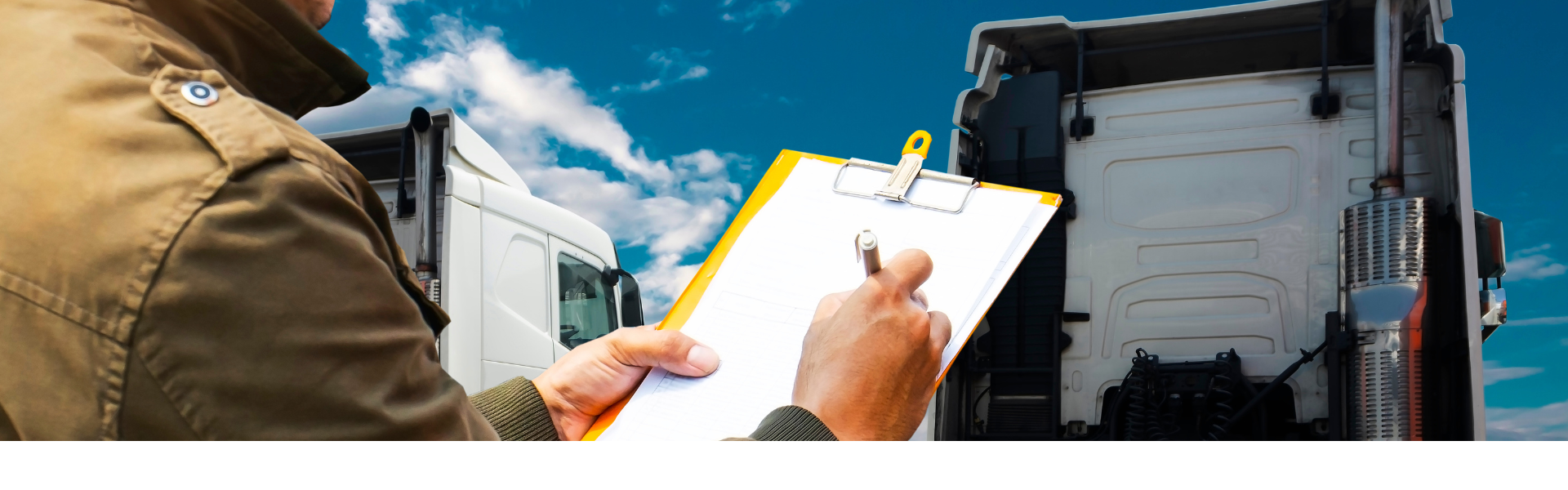 man holding clipboard and pen with semi truck in background