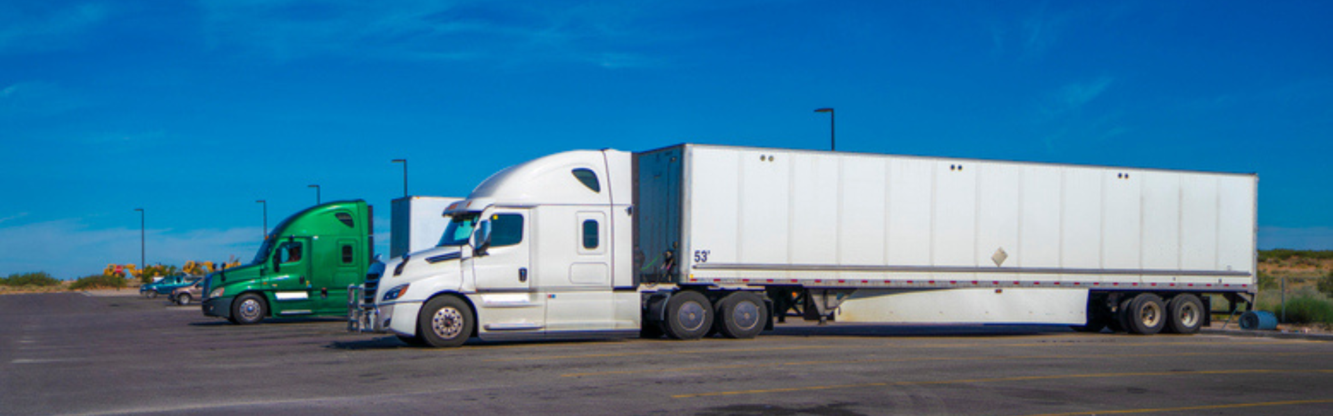 two semi trucks parked in parking lot