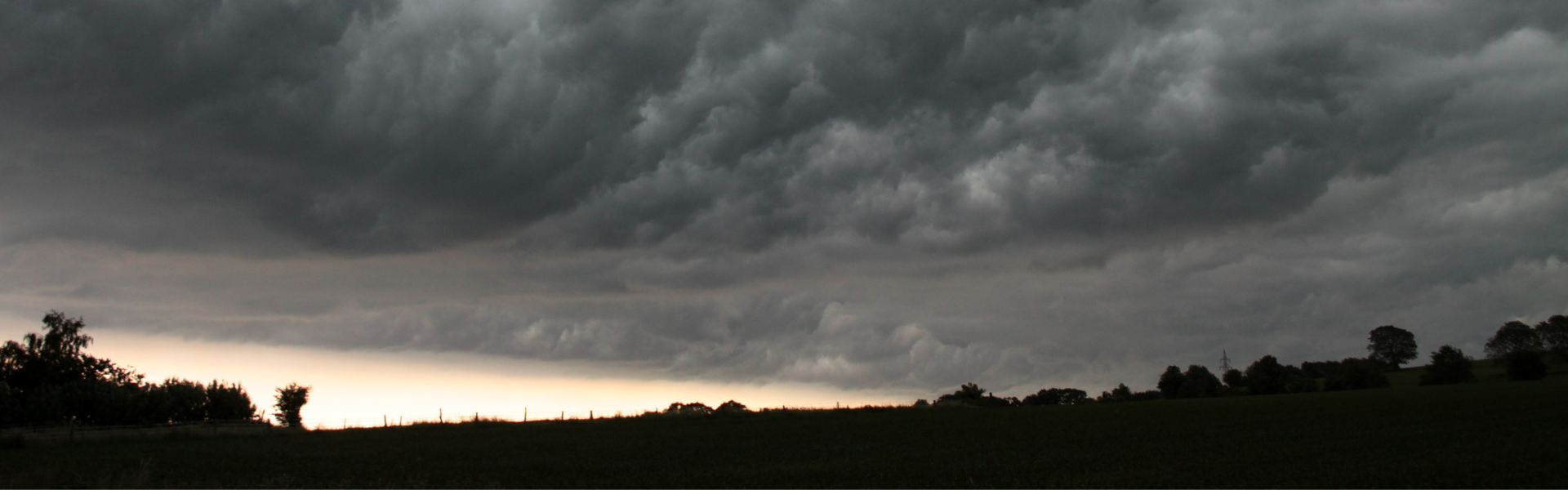 storm clouds over a silhouetted landscape