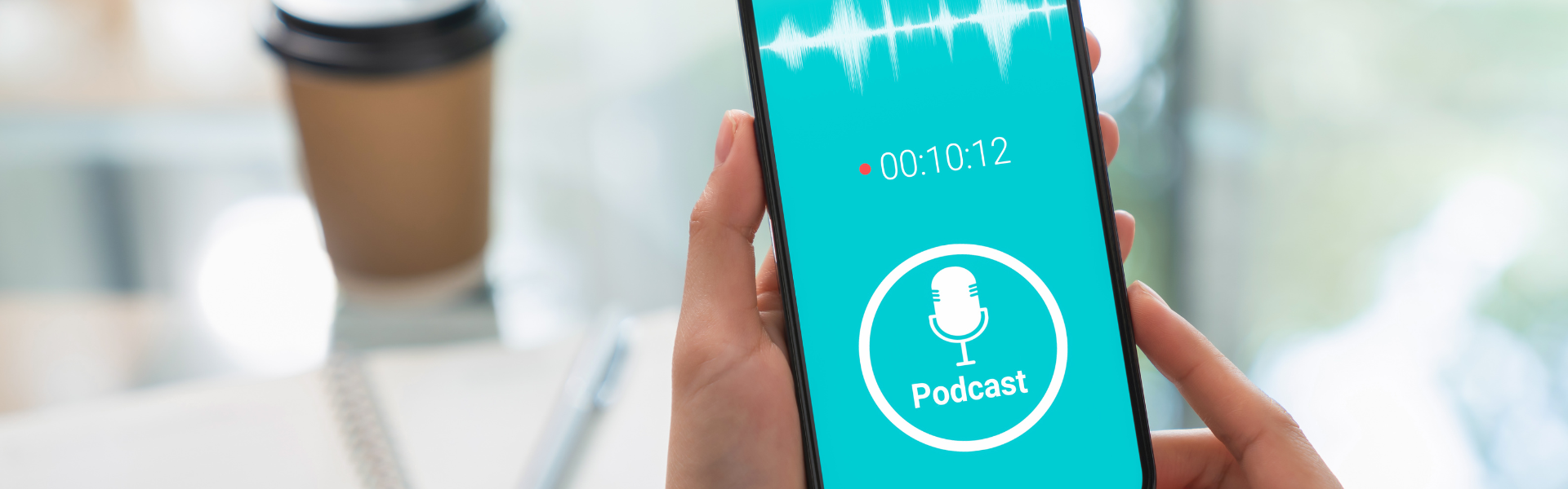 listening to podcast on phone with coffee cup in background