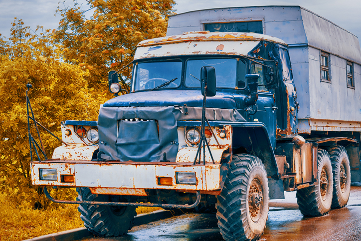 Vintage truck with patches on the cab and a living compartment in the back