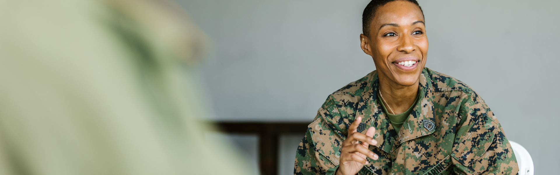 black woman dressed in military uniform talking in a group setting