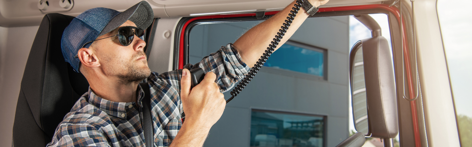 semi truck driver in cab talking on CB