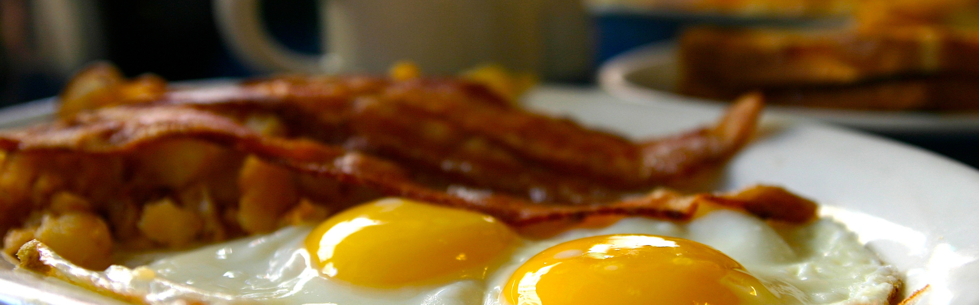 bacon and eggs on a plate at a diner
