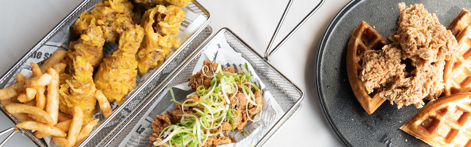 variety of plates featuring comfort foods such as fried chicken and chicken and waffles