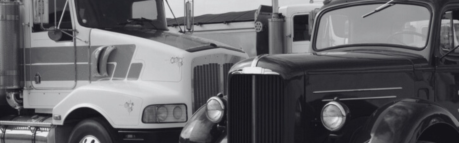 black and white photo of older and newer semi truck