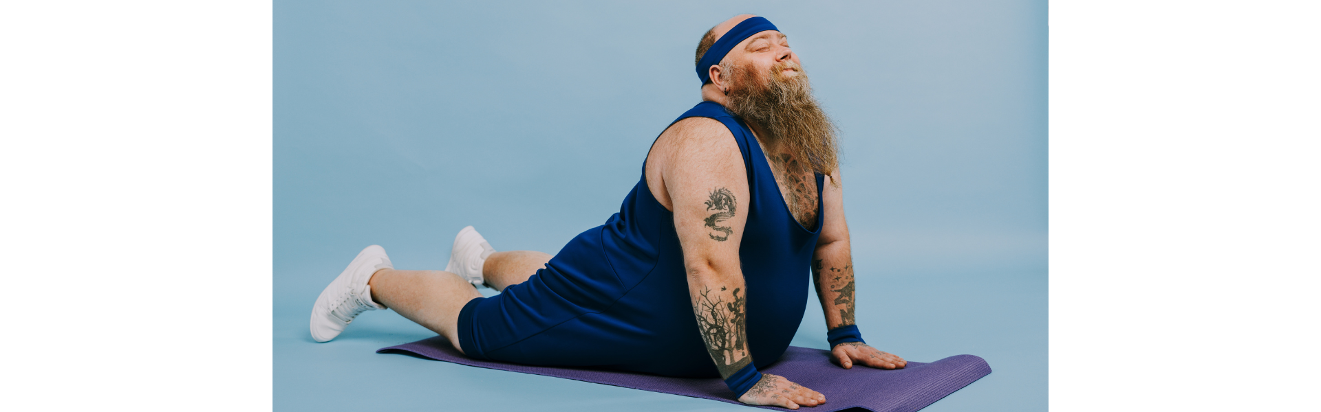 man with long beard and tattoos doing yoga