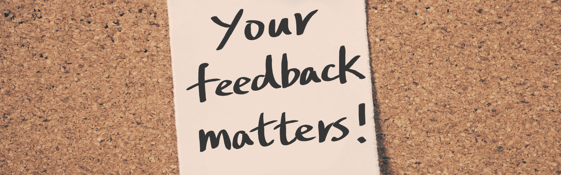 post it note with "your feedback matters" written on it in marker posted to a cork bulletin board