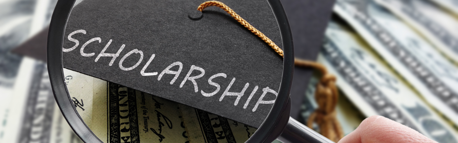 graduation cap with the word scholarship printed on it under a magnifying glass with money bills in the background