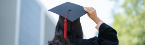 Girl facing away from camera in graduation cap and gown, transerivce 2024 scholarship awardees