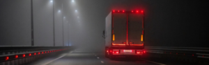 semi truck driving at night with brake lights lit up