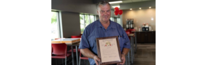 john moeller holding his 6 million mile plaque