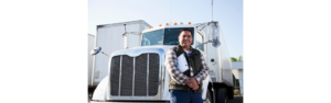 man holding clipboard standing in front of semi truck