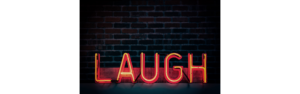 red neon laugh sign with a black brick background