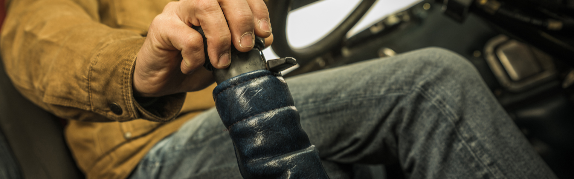 trucker with hand on gear shift in semi truck cab, of floating gears in your semi-truck with expert tips on throttle control, timing, and avoiding forced shifts