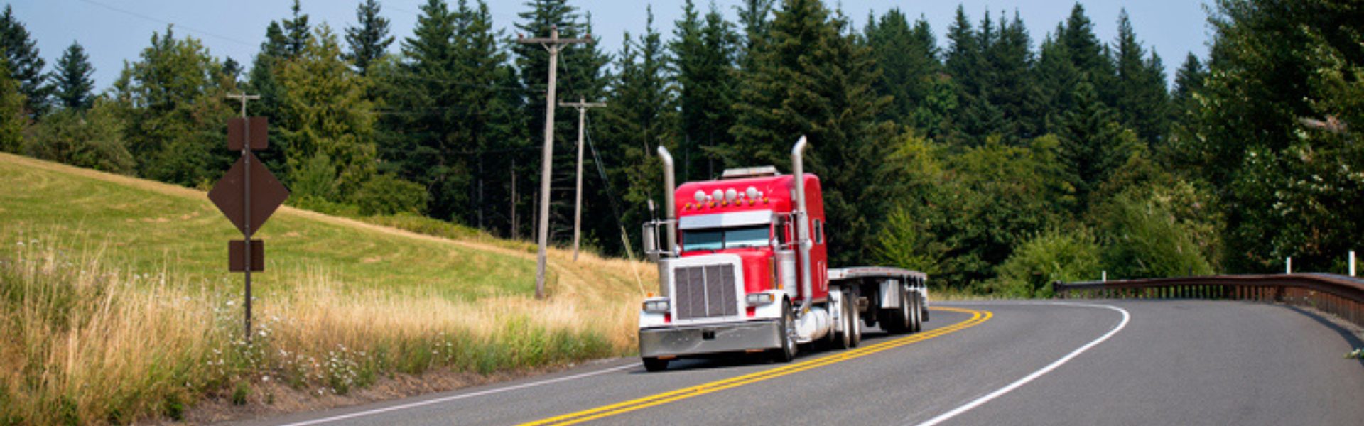 red peterbilt semi truck on tree-lined road, Peterbilt renews its commitment to future trucking leaders by sponsoring the ATA Trucking U program for the second year.