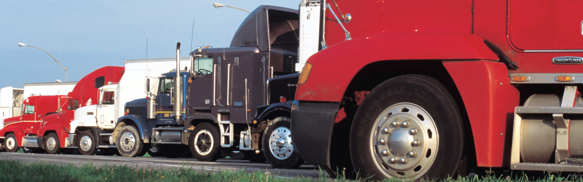 variety of semi trucks parked in a row in a truck parking lot ; TravelCenters of America has opened two new TA Express locations along I-81 in Pennsylvania, adding 287 truck parking spaces