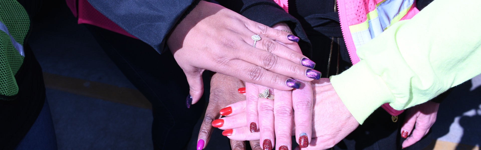 women truckers put their hands in to show solidarity and teamwork NFI She Drives