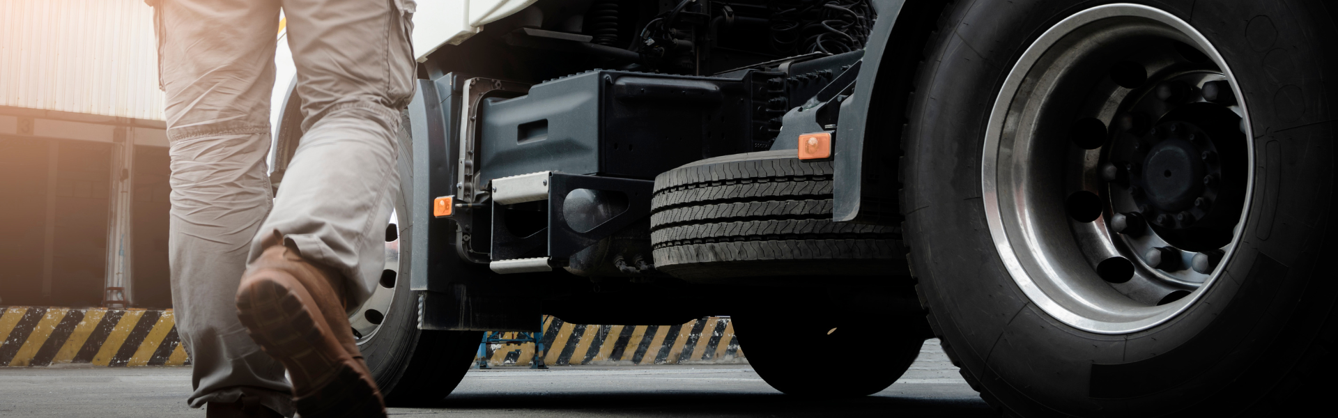 man in work boots walking toward semi truck in sunlight. unforgettable first-day stories of truck drivers across America
