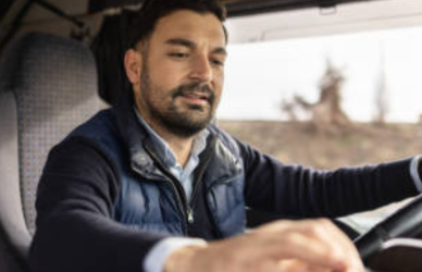 trucker in cab looking at laptop