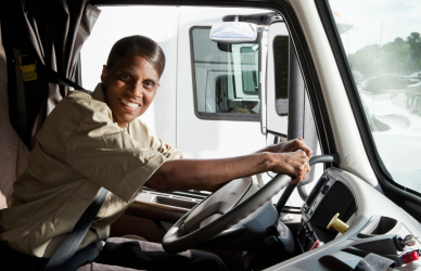 smiling black woman driving semi truck