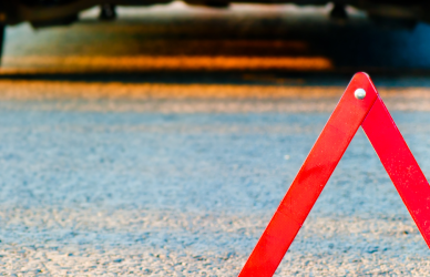 Car pulled over with red caution triangle behind the vehicle