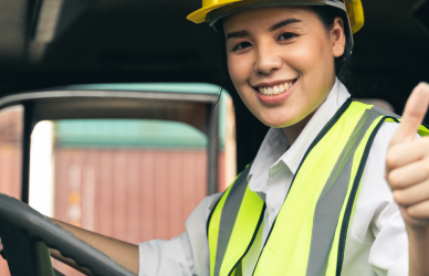 woman sitting behind the wheel of a semi truck