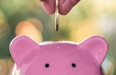 dropping a coin into a piggy bank