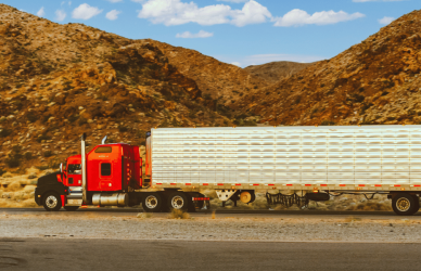semi truck on road with mountains in the background