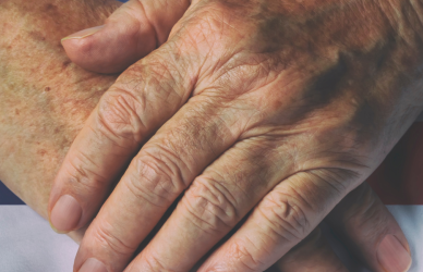 hands folded over flag