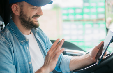 Trucker sitting in cab using tablet for video call