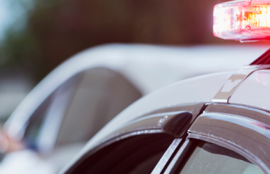 police officer with someone pulled over on side of road. police car with lights on