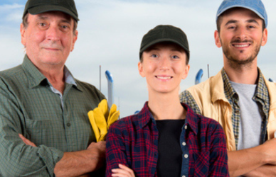 man with younger woman and younger man standing in front of semi trucks