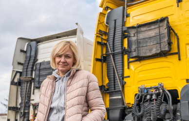 Woman standing by yellow semi truck
